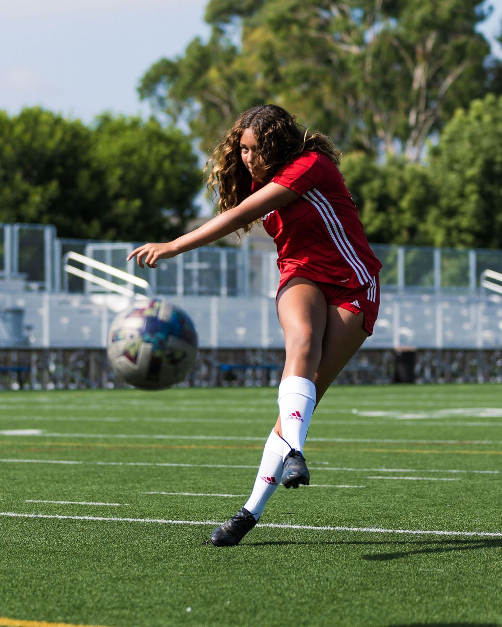 OLu women’s soccer player takes a shot on goal during a match, captured by Chris Cornish Photography.