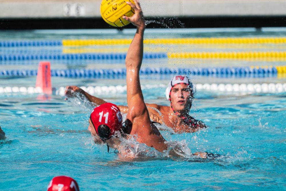 OLu men’s water polo player rises out of the pool to take a shot during a match, captured by Chris Cornish Photography.