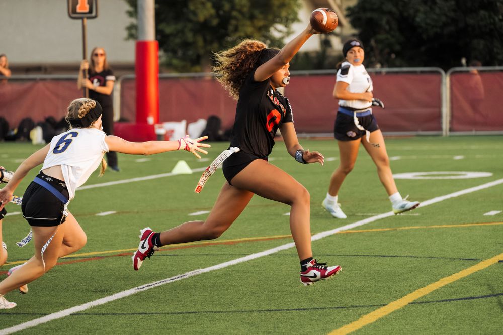 OLu women’s flag football player runs with the ball during a game, captured by Chris Cornish Photography.