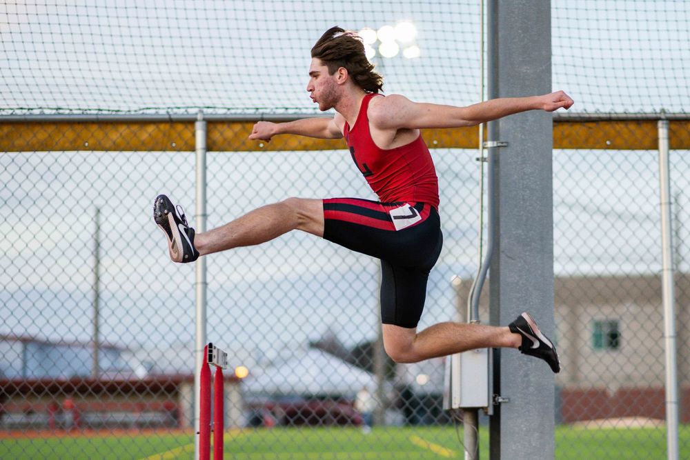 OLu track and field runner sprints down the lane during a race, captured by Chris Cornish Photography.