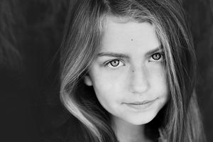 Black and white close-up portrait of a young girl with long hair and a soft, gentle expression.