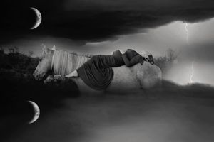 Surreal black and white maternity art of a woman resting on a white horse under crescent moons and lightning in a stormy night sky.