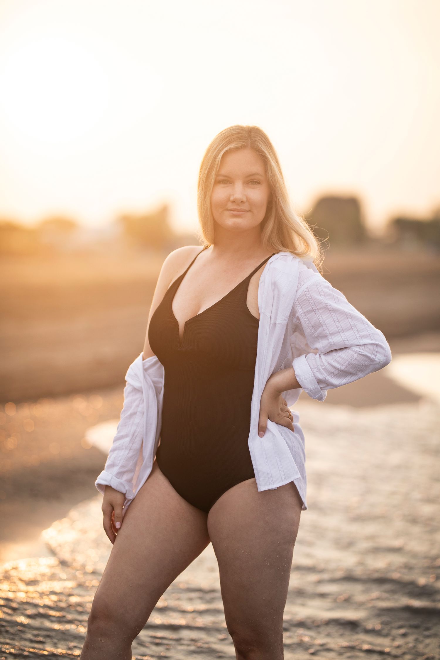Beach portrait at sunset featuring a black swimsuit and white cover-up shirt.