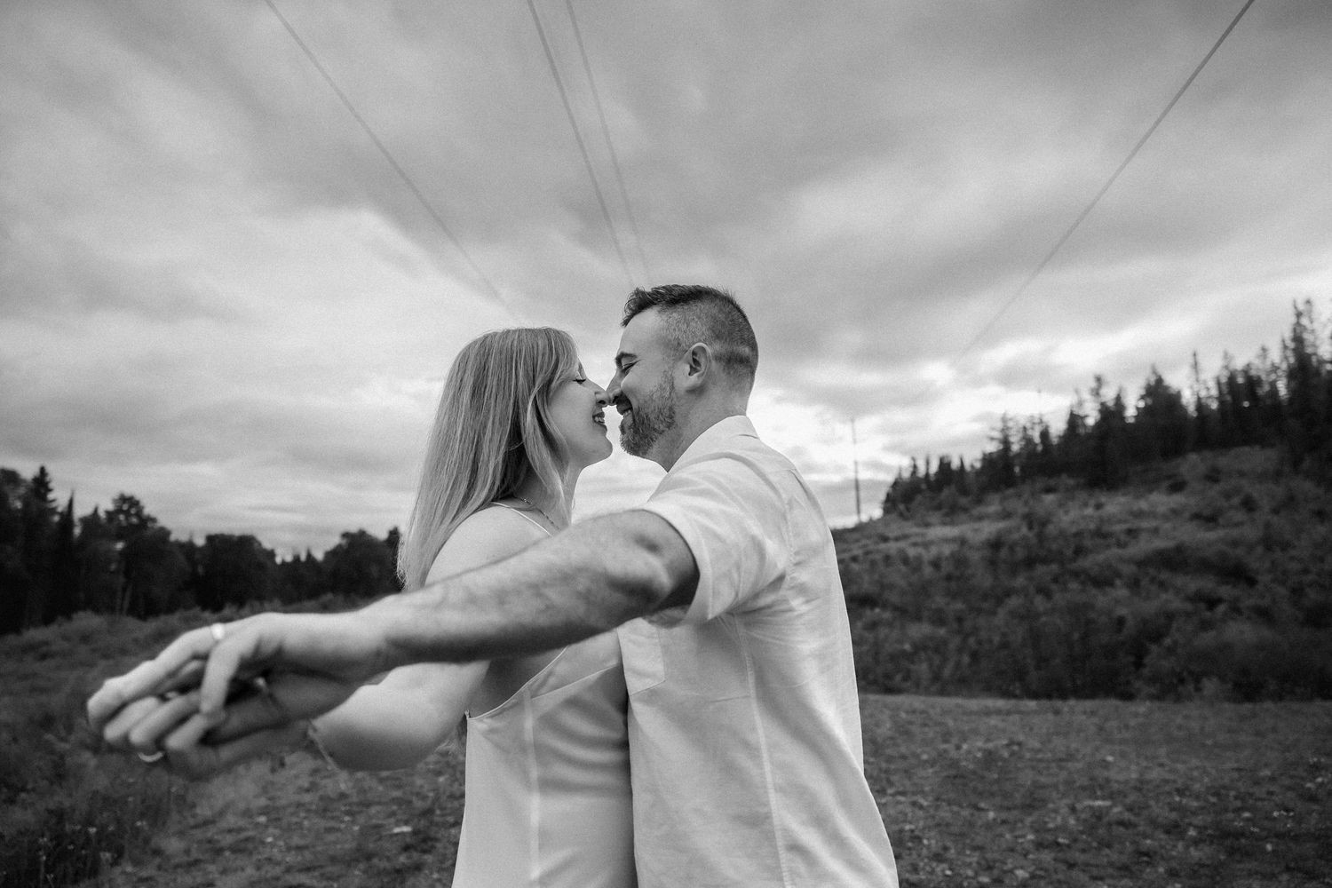Black and white family portrait in wooded setting during maternity photoshoot.