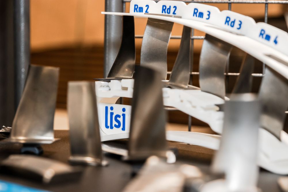 Close-up of LISI aerospace metal components organized in labeled slots marked Rm2, Rd2, Rm3, Rd3, and Rm4.