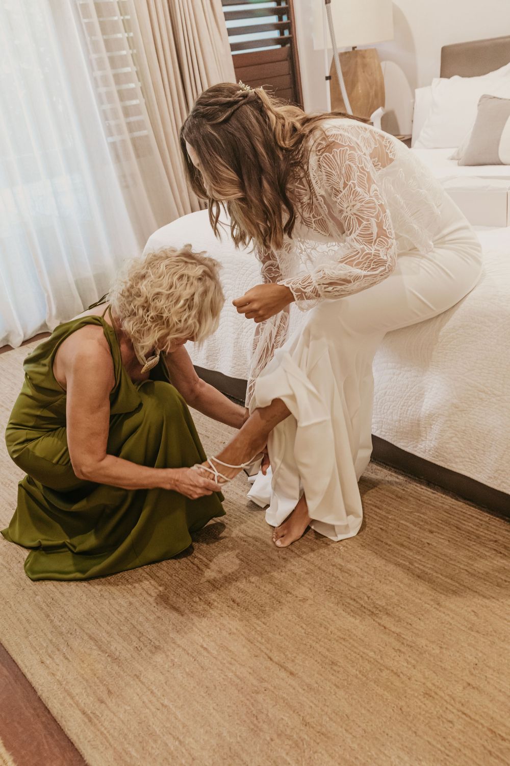 Bride getting ready as her mother helps fasten her wedding shoes before an elegant Byron Bay wedding.