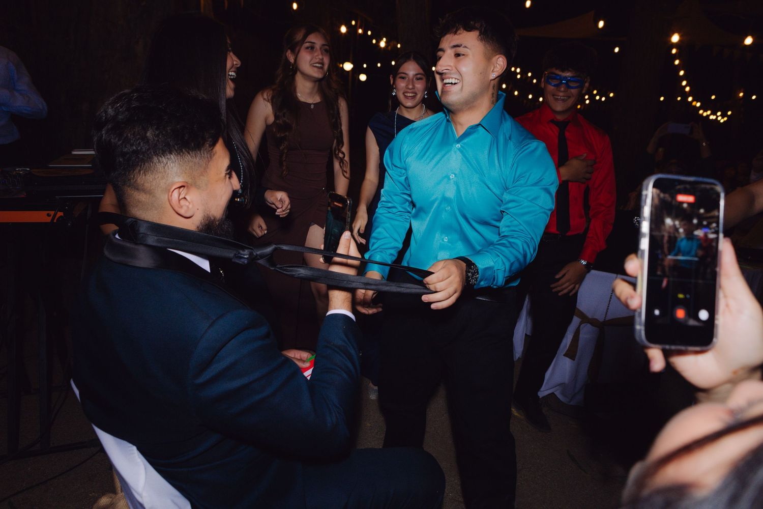 Two men sharing a fun moment on the wedding reception dance floor.