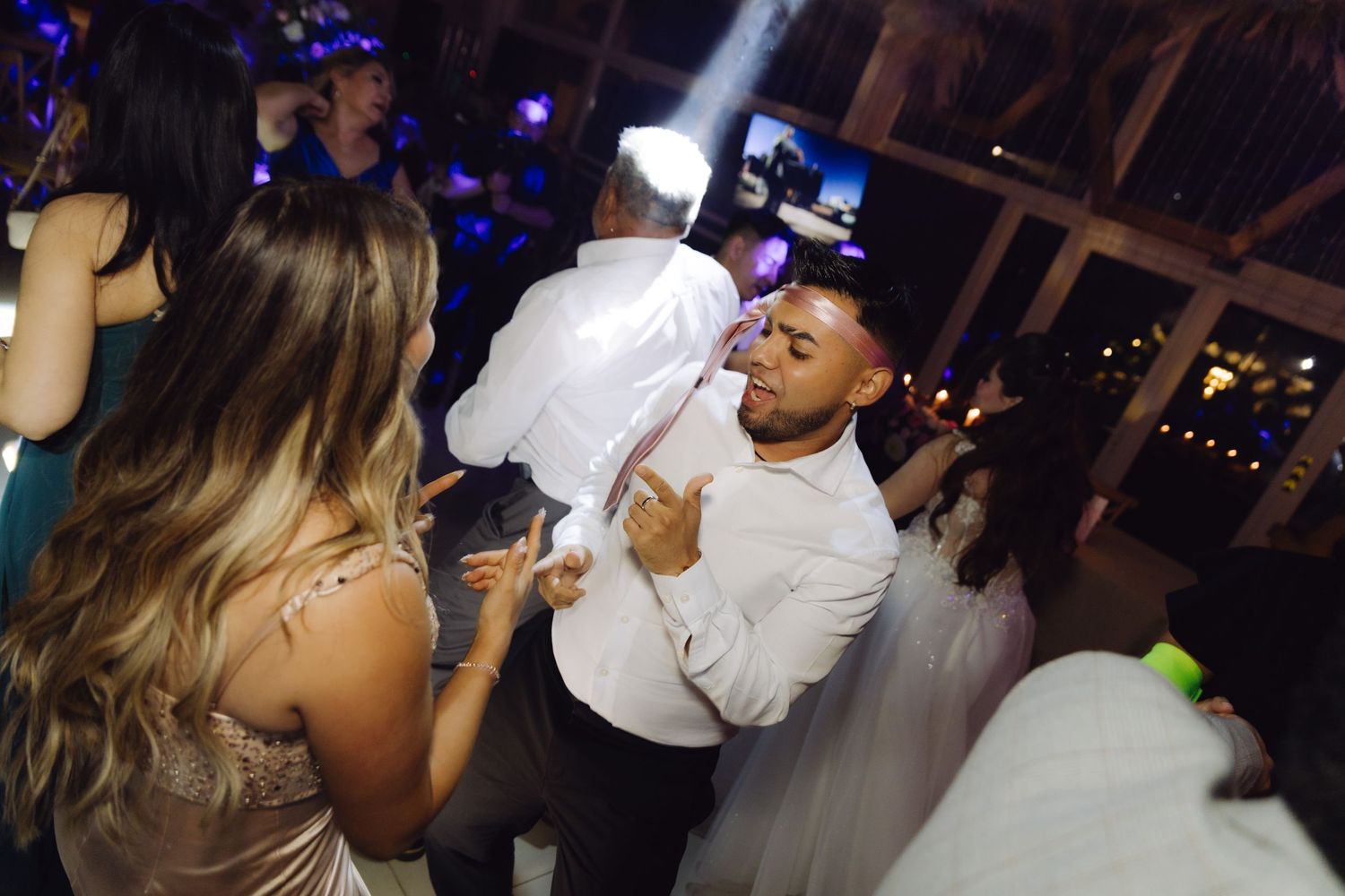 Bride and groom sharing romantic dance moment together on wedding reception dance floor at night.
