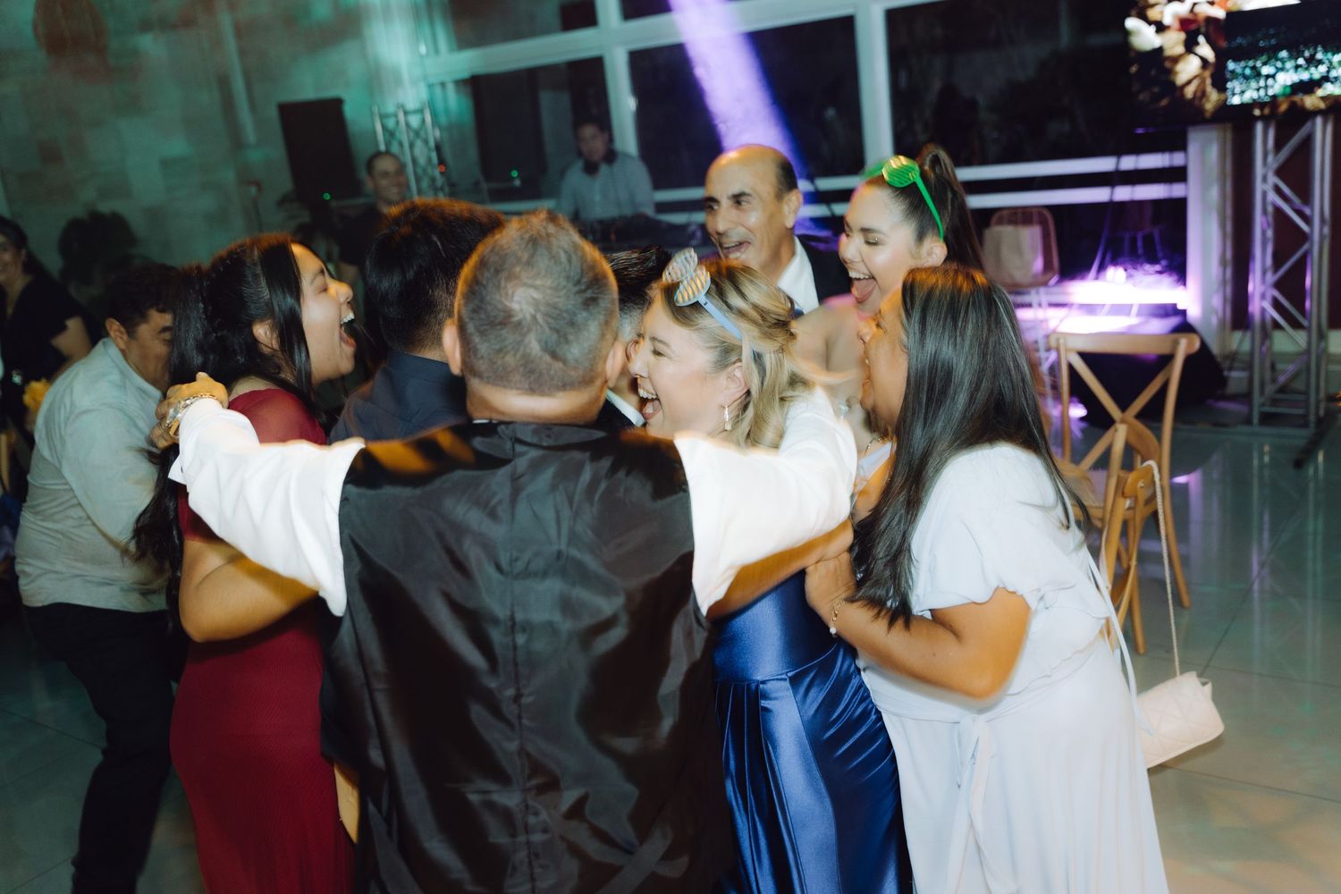 Wedding guests dancing and celebrating together on the dance floor at an elegant reception venue.
