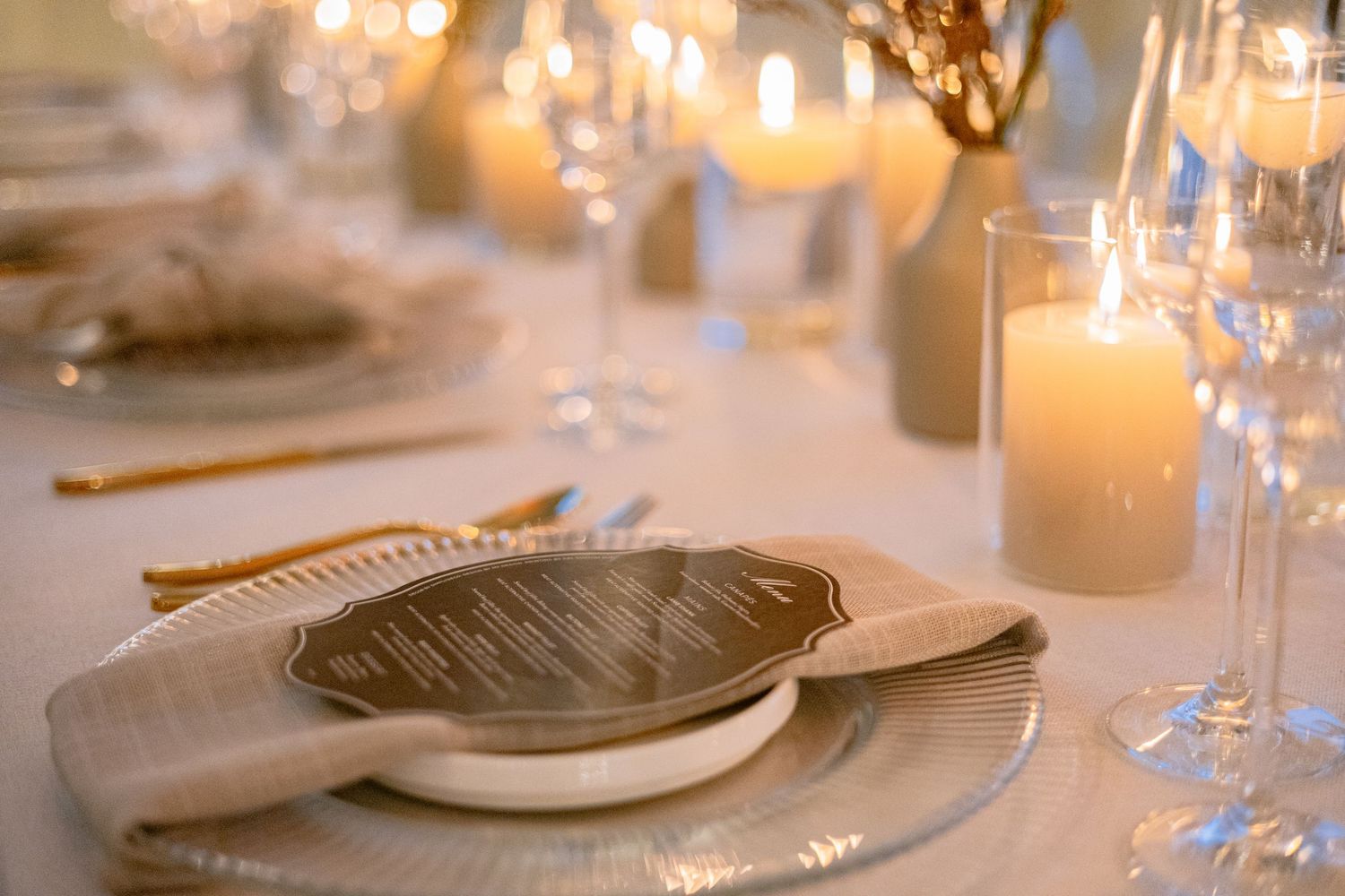 Wedding table décor featuring flowers, candles and personalised place settings.