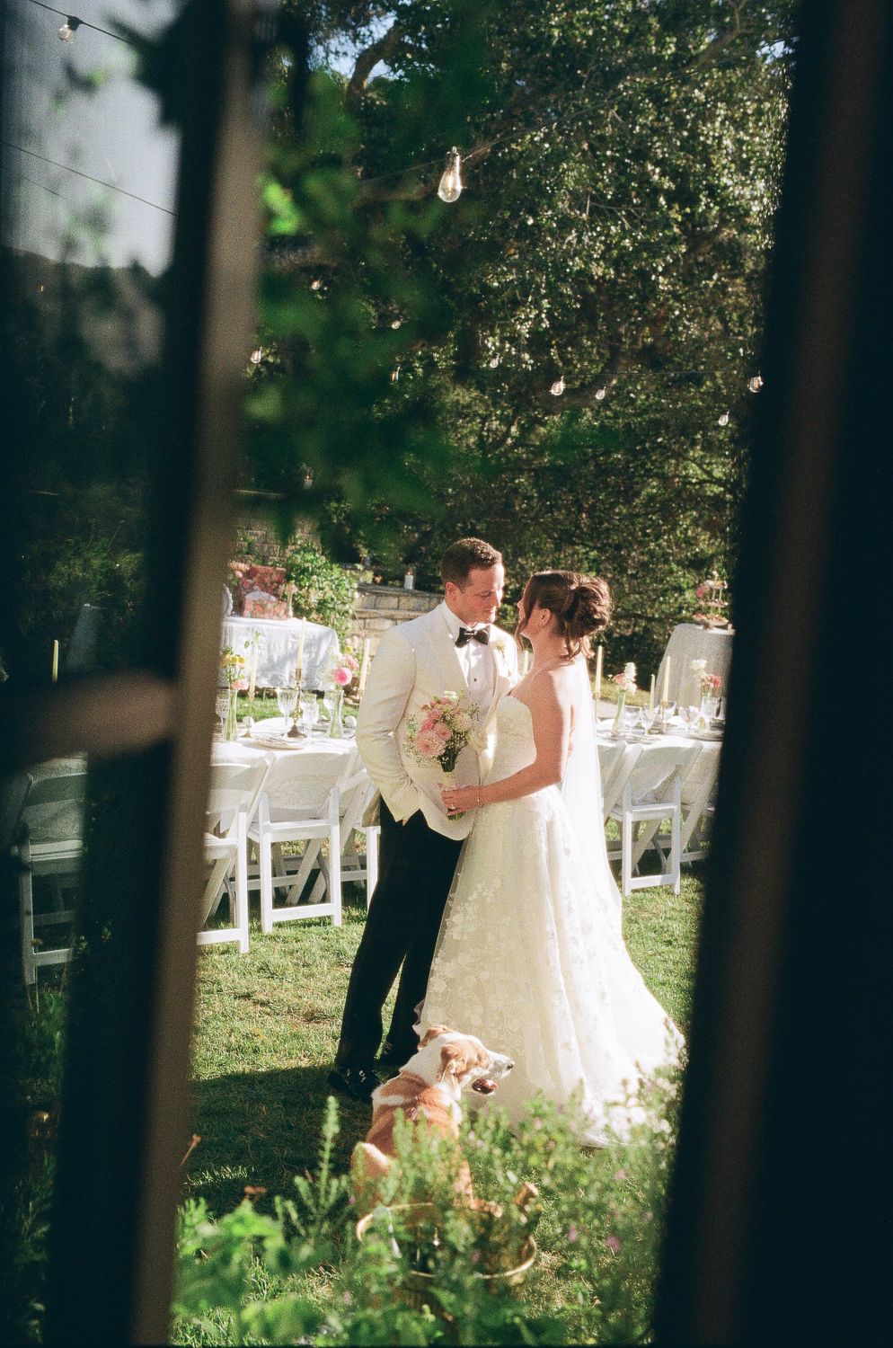 A candid documentary film photo of a couple in a courtyard as the photographer looks through the window.