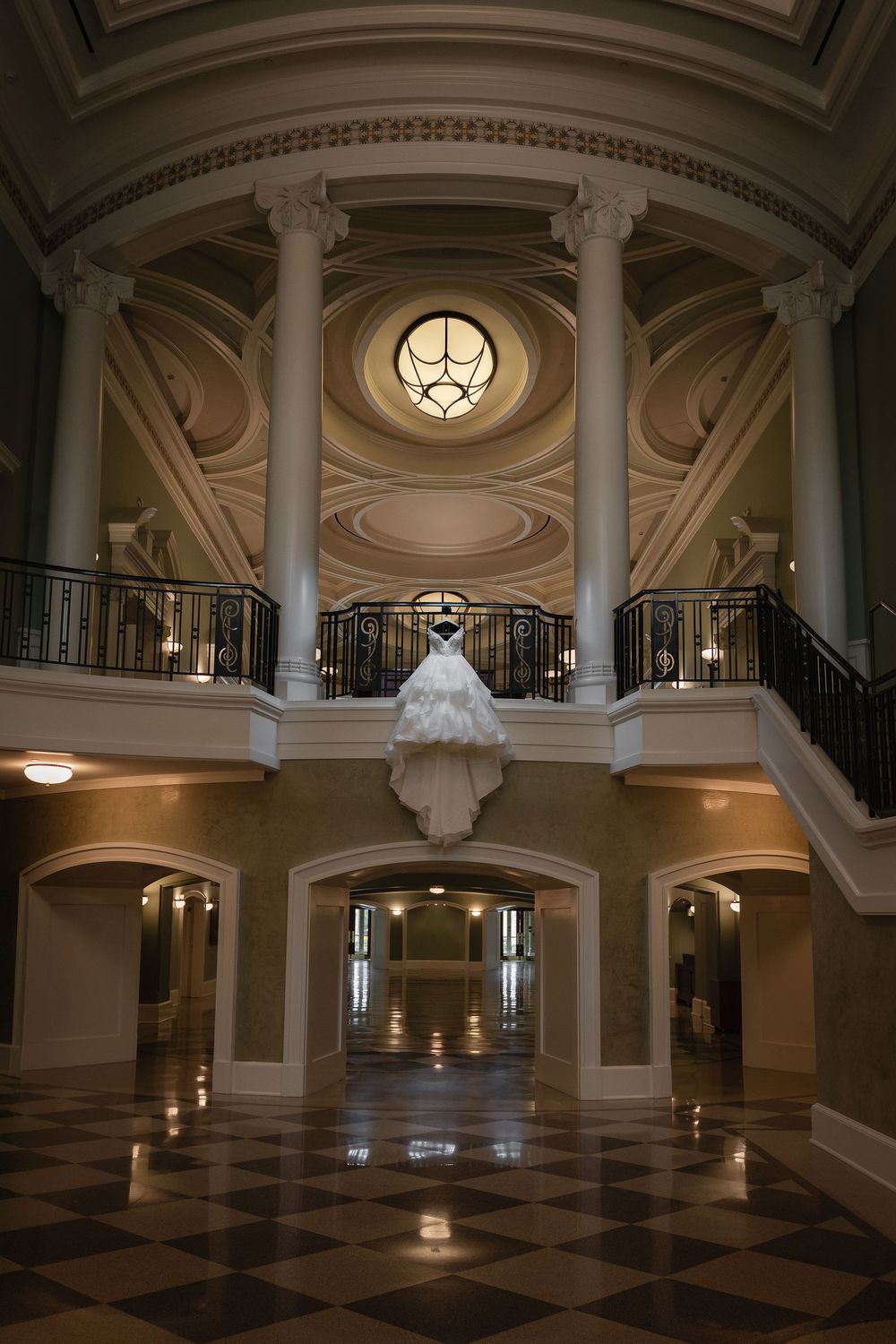 Wedding dress hanging from a balcony in a domed rotunda at the Galliard Center, Charleston, SC