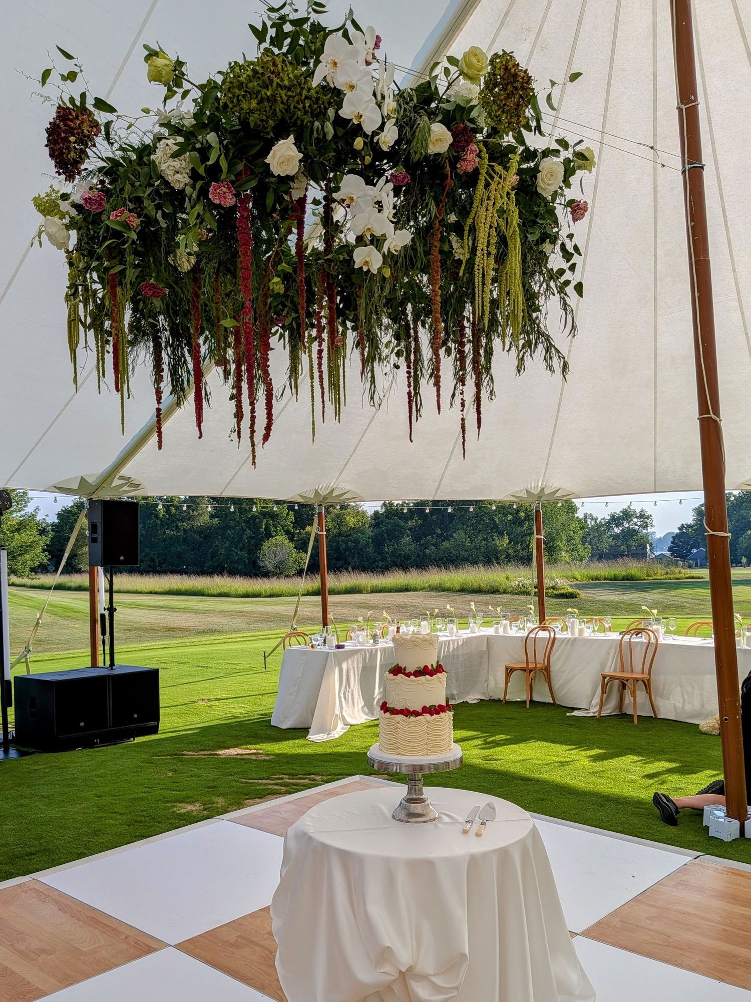 Elegant wedding ceiling decor featuring mirrored disco balls and lush greenery with pink and blue flowers on white background.