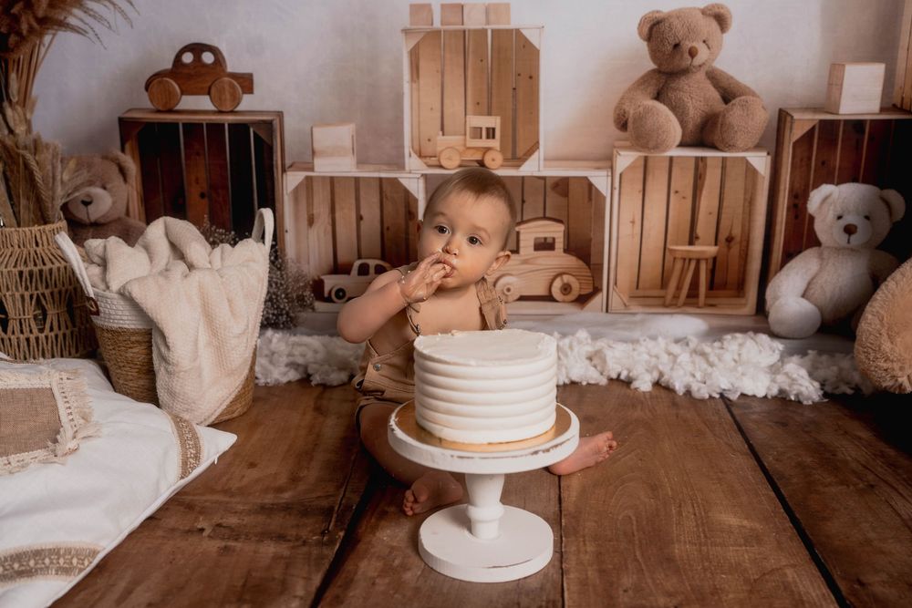Un bébé mange son premier gâteau d'anniversaire lors d'une séance photo smash cake