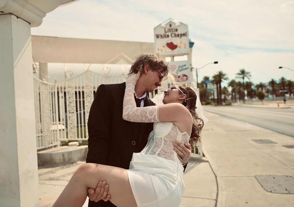 Couple sharing a romantic kiss outside the Little White Chapel wedding venue in Las Vegas, Nevada.