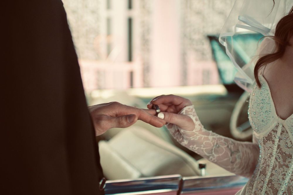 Bride placing a wedding ring on grooms hand during intimate Las Vegas wedding ceremony.
