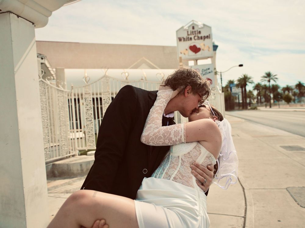 Couple sharing a romantic kiss outside the Little White Chapel wedding venue on the Las Vegas Strip.