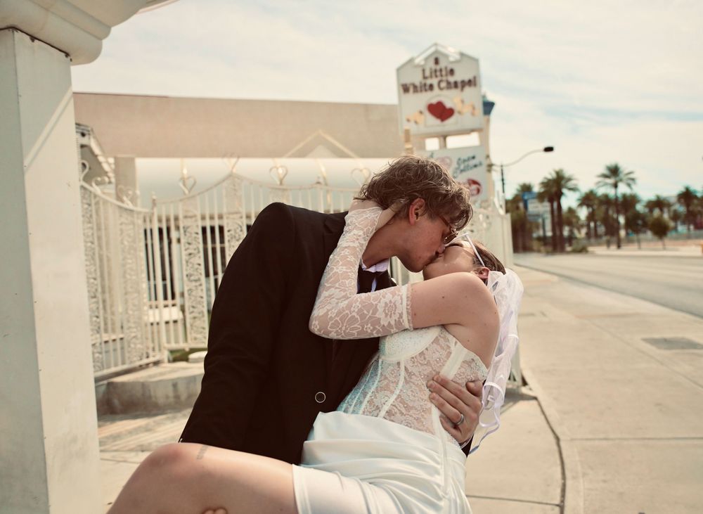 Couple sharing a romantic kiss outside the Little White Chapel wedding venue in Las Vegas, Nevada.