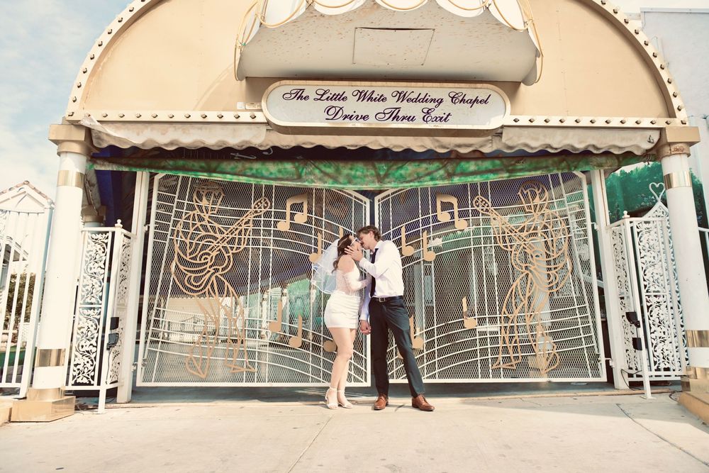 Couple embracing outside The Little White Wedding Chapel drive-thru in Las Vegas.