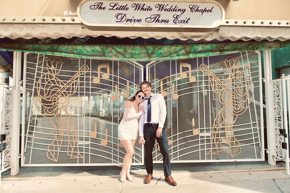 Couple posing outside The Little White Wedding Chapel Drive Thru in Las Vegas, Nevada.