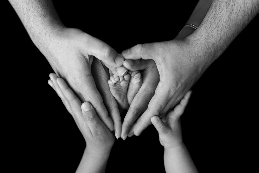 Black and white photo series showing close-up shots of hands with various intimate holding and touching gestures.