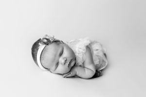 An artistic collage of 4 peaceful newborn photographs showing infants sleeping in different serene poses.