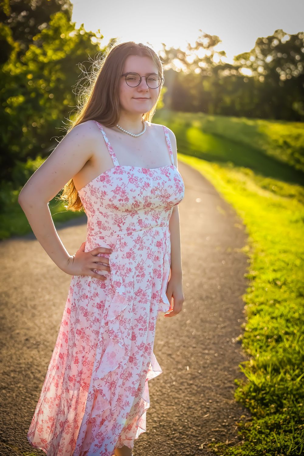 Sunset photoshoot on a path featuring a floral pink dress in golden hour lighting.