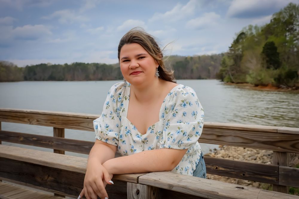 Portrait series by a wooden dock overlooking a lake in blue floral dress.