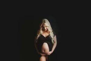 Minimalist black and white studio portrait with dramatic lighting.
