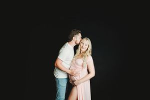 Romantic couple's maternity photos against a dark background.