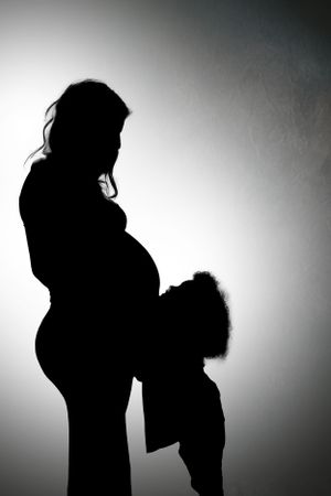Dramatic black and white silhouette portraits showing tender family interactions.
