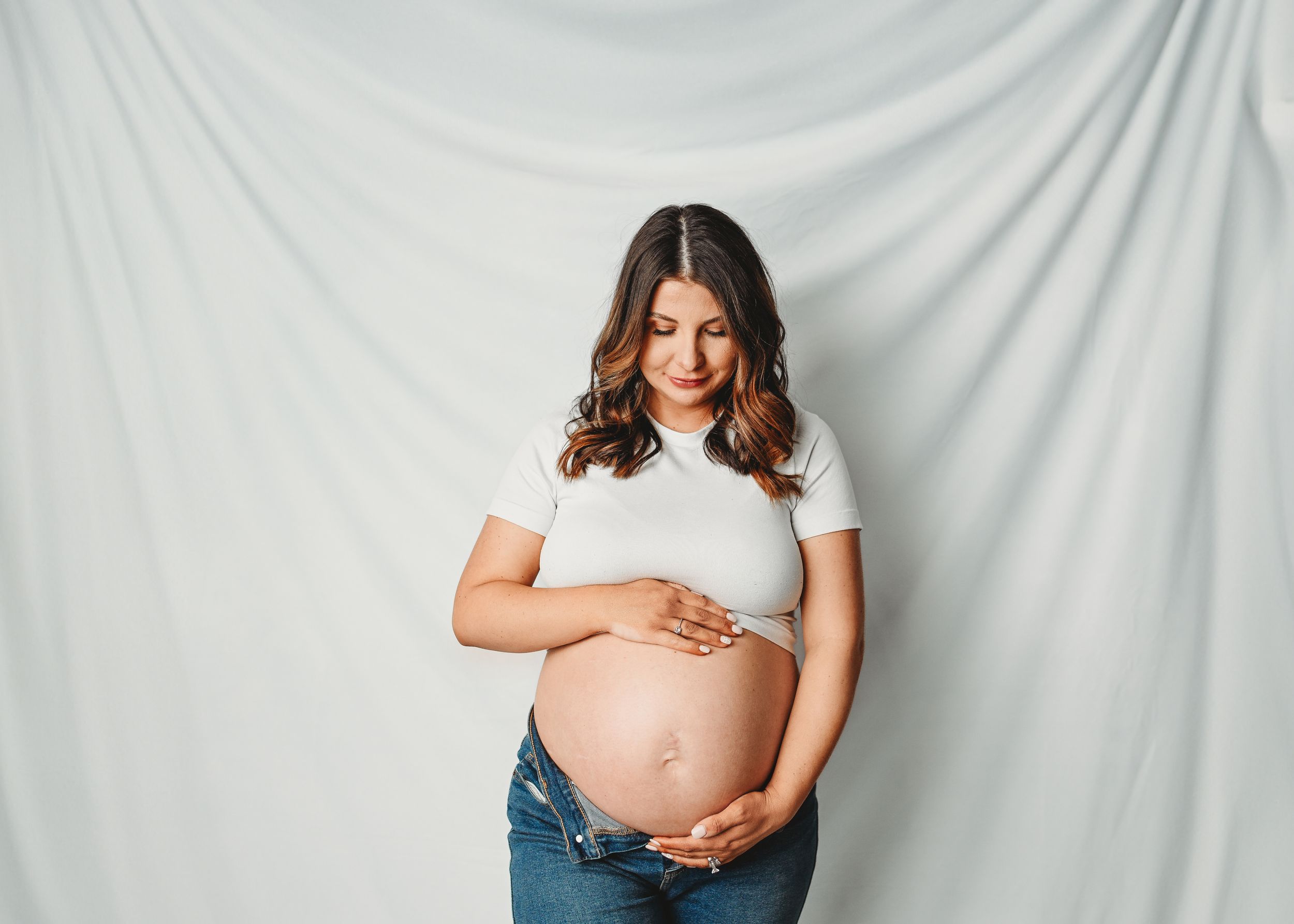 Candid maternity session showing joyful moments against white background.