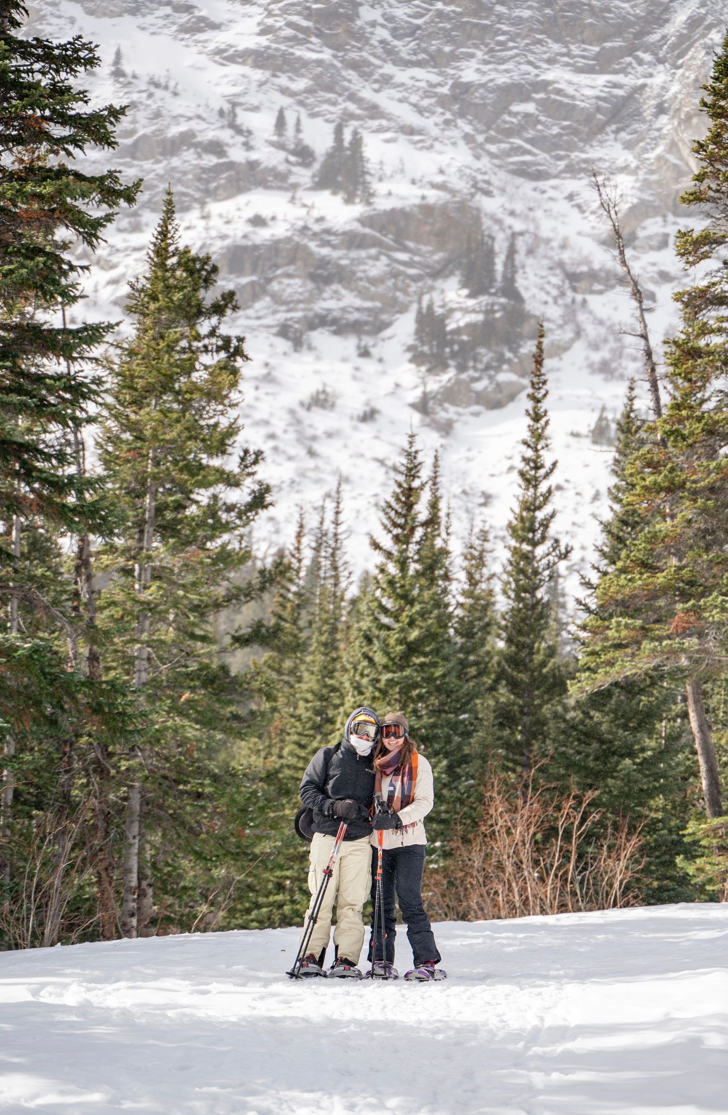 A couple hugging in a snow landscape while snowshoeing