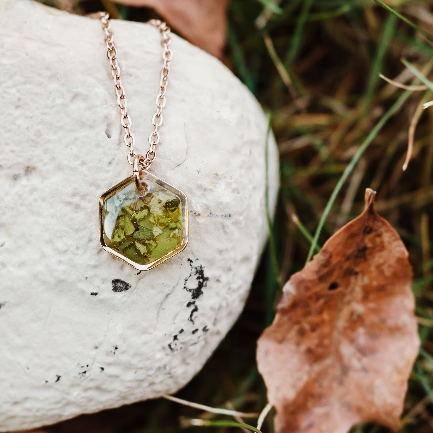 resin filled necklace sitting on a rock backdrop in nature