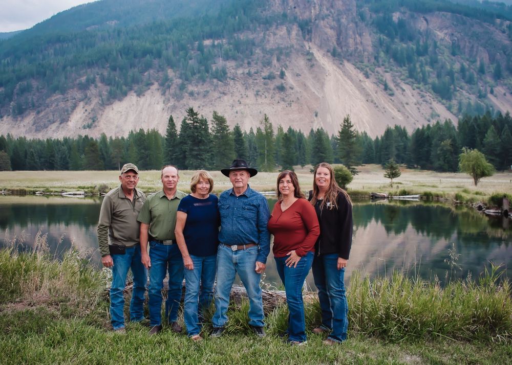 A family group poses together by a lake with mountain scenery in the background.
farmers, Montana