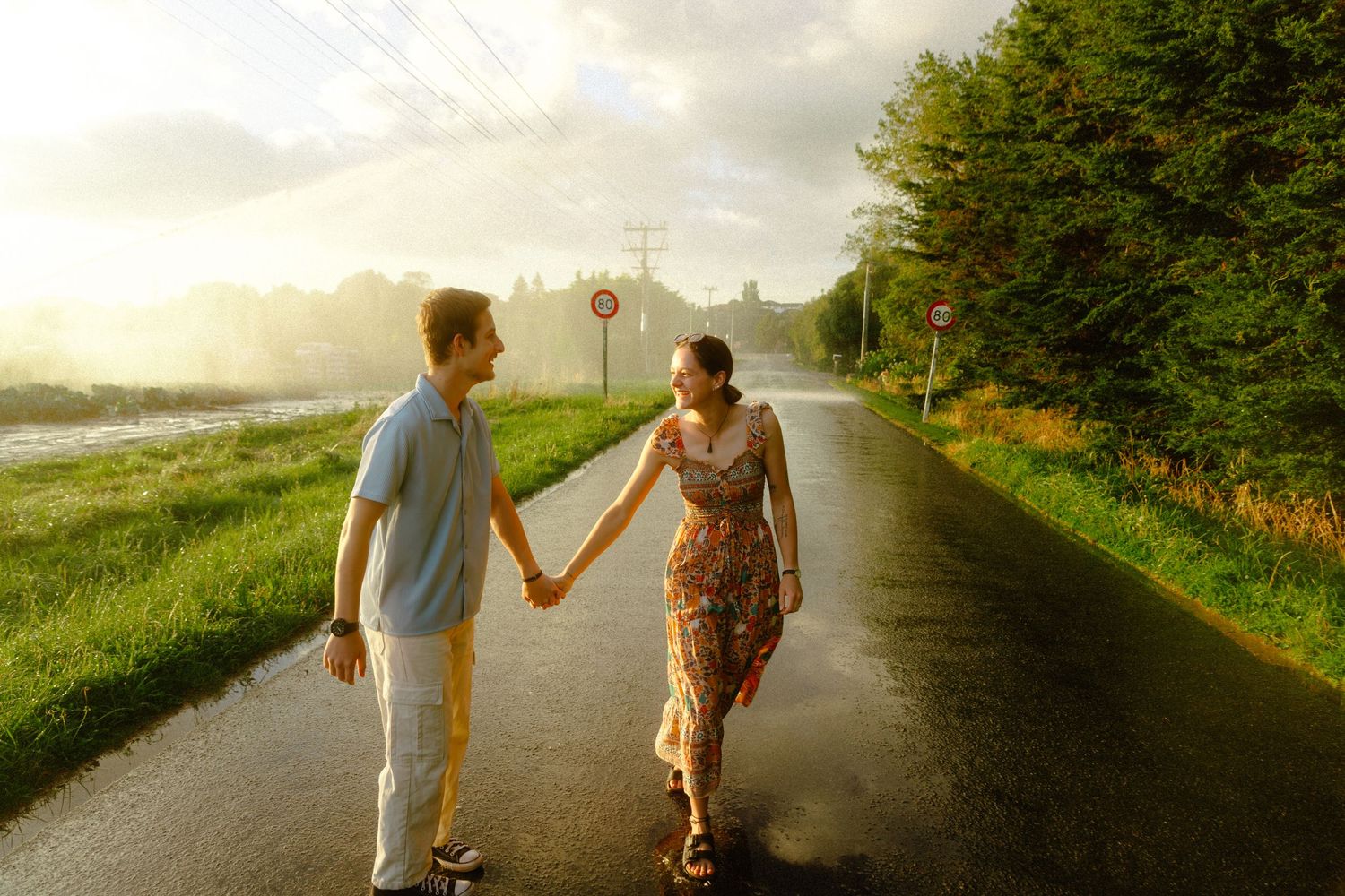 Couple holding hands along the Manawatu River in Palmerston North - golden-hour engagement shoot by Selah Weddings.