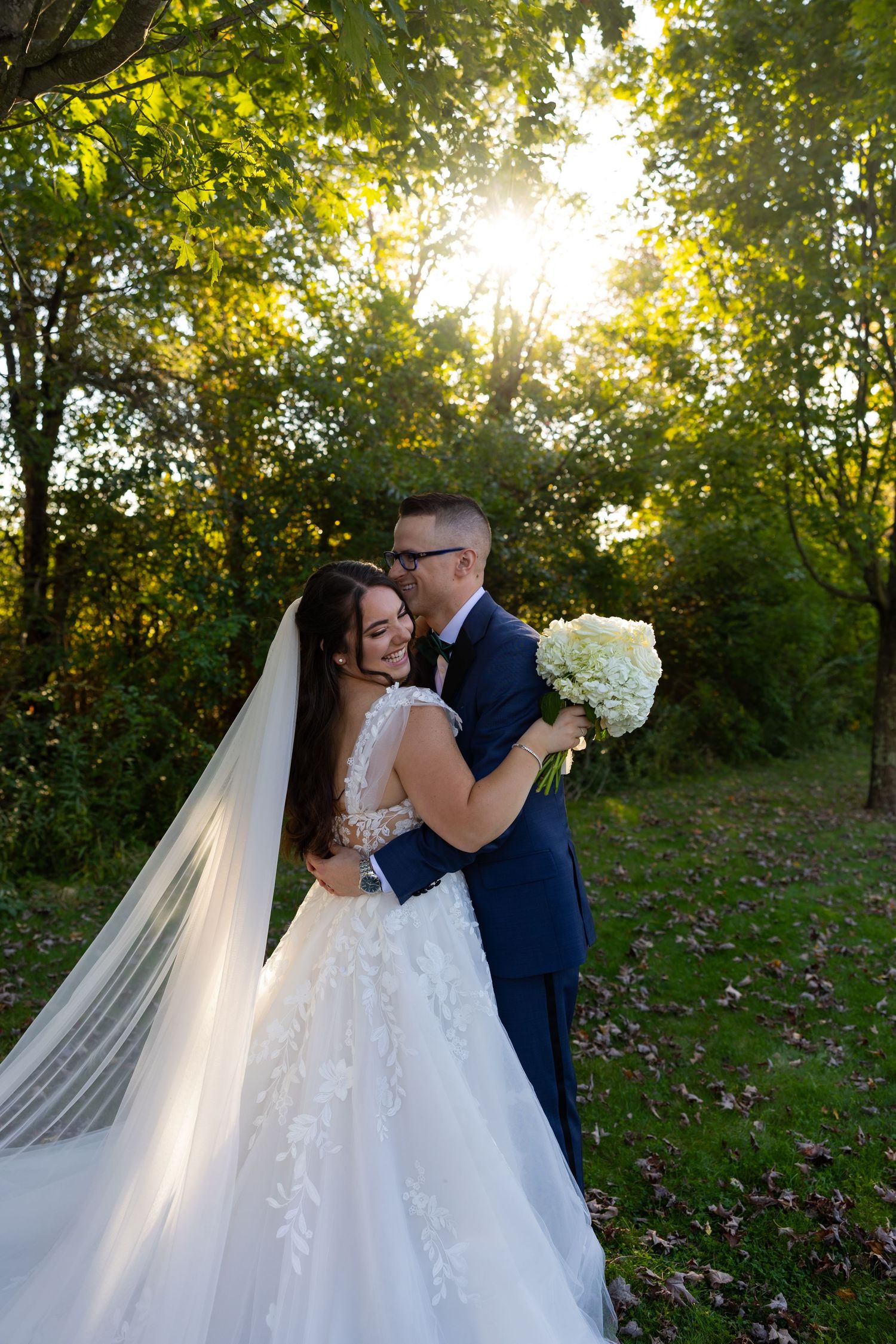 A couple takes a romantic stroll together on a winding path through a lush green park.