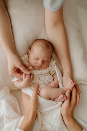 parents holding babies hands on beanbag in hamilton studio