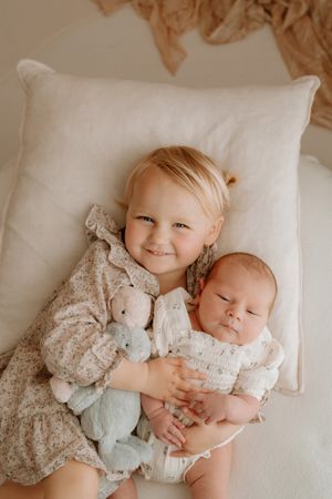 cutest sisters posing on bean bag for hamilton waikato newborn shoot