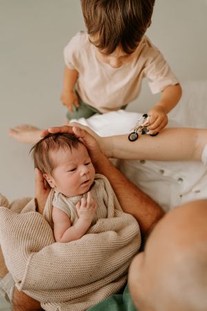 brother driving his motorbike up to newborn babies head in hamilton waikato studio