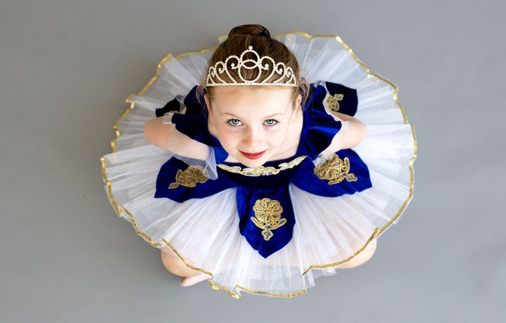 Ballet dancer in white and blue performance tutu with tiara.