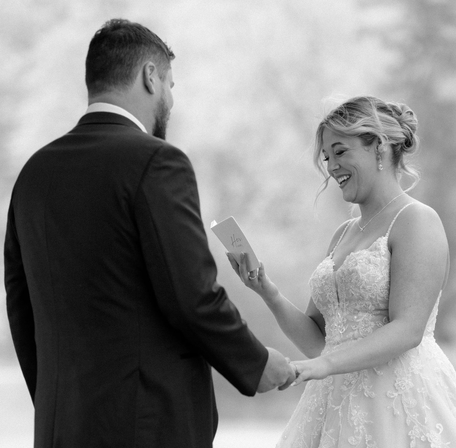 A couple shares an emotional moment while exchanging vows during their outdoor wedding ceremony.