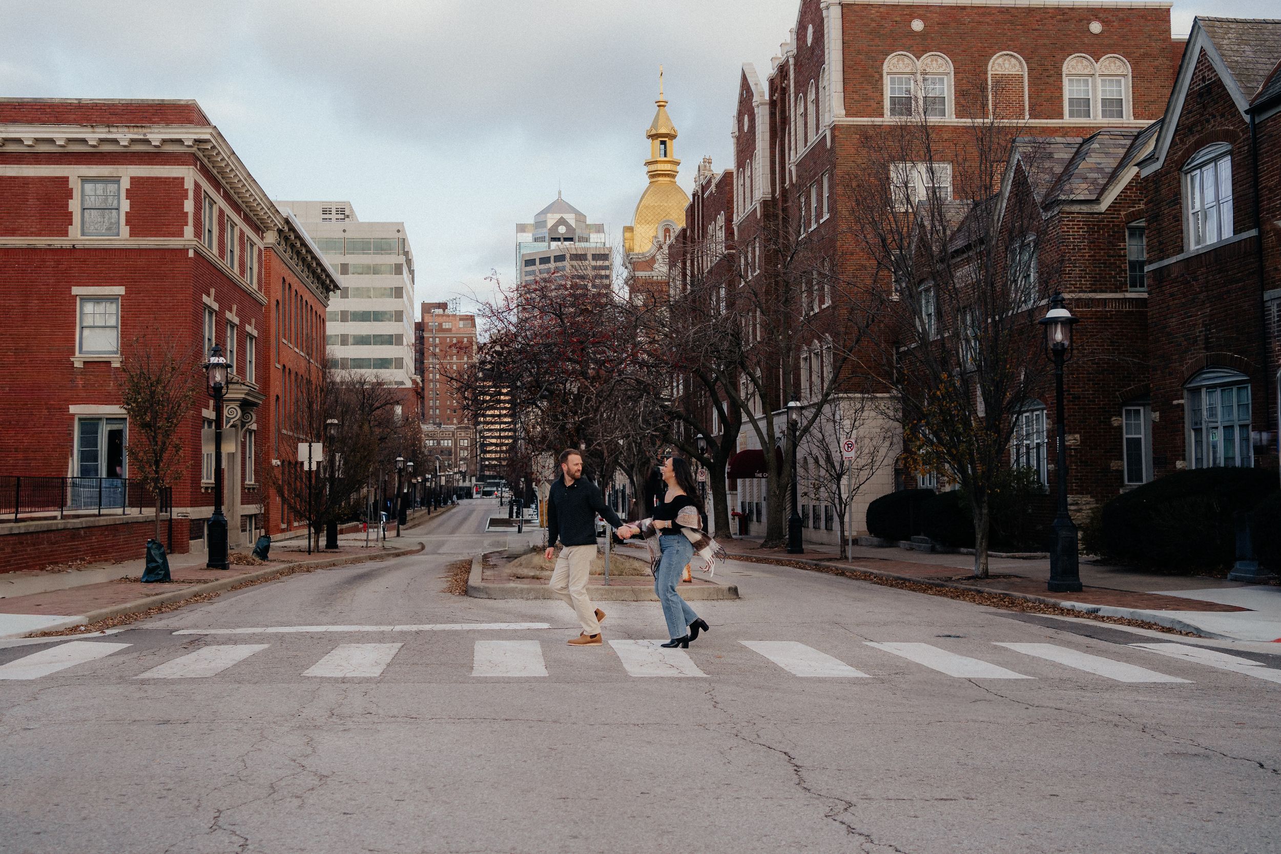 Urban street view with brick buildings, crosswalks and sidewalks in a historic downtown area during daytime.