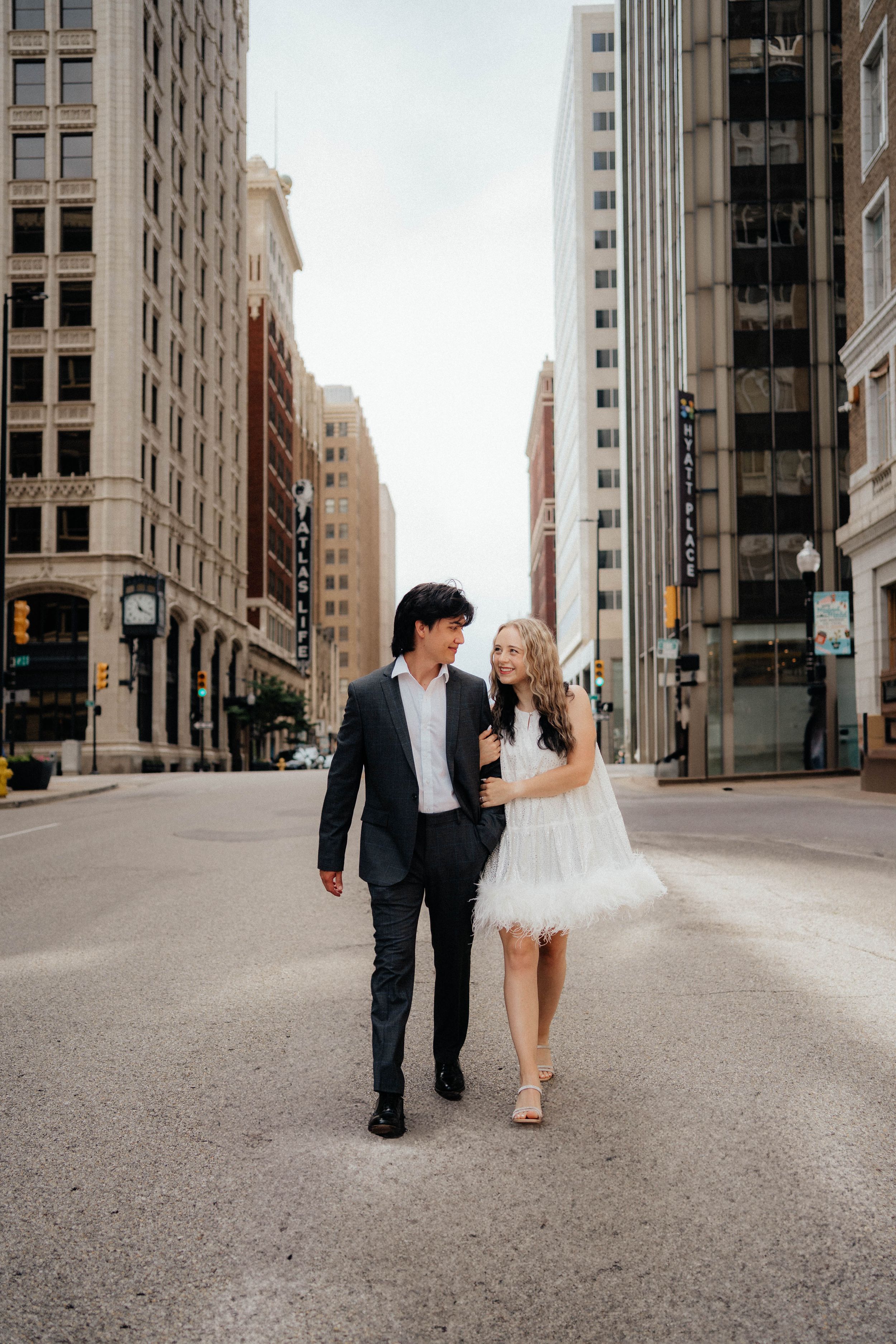 A couple sets off on an urban engagement photoshoot series showing a walk down an empty city street.