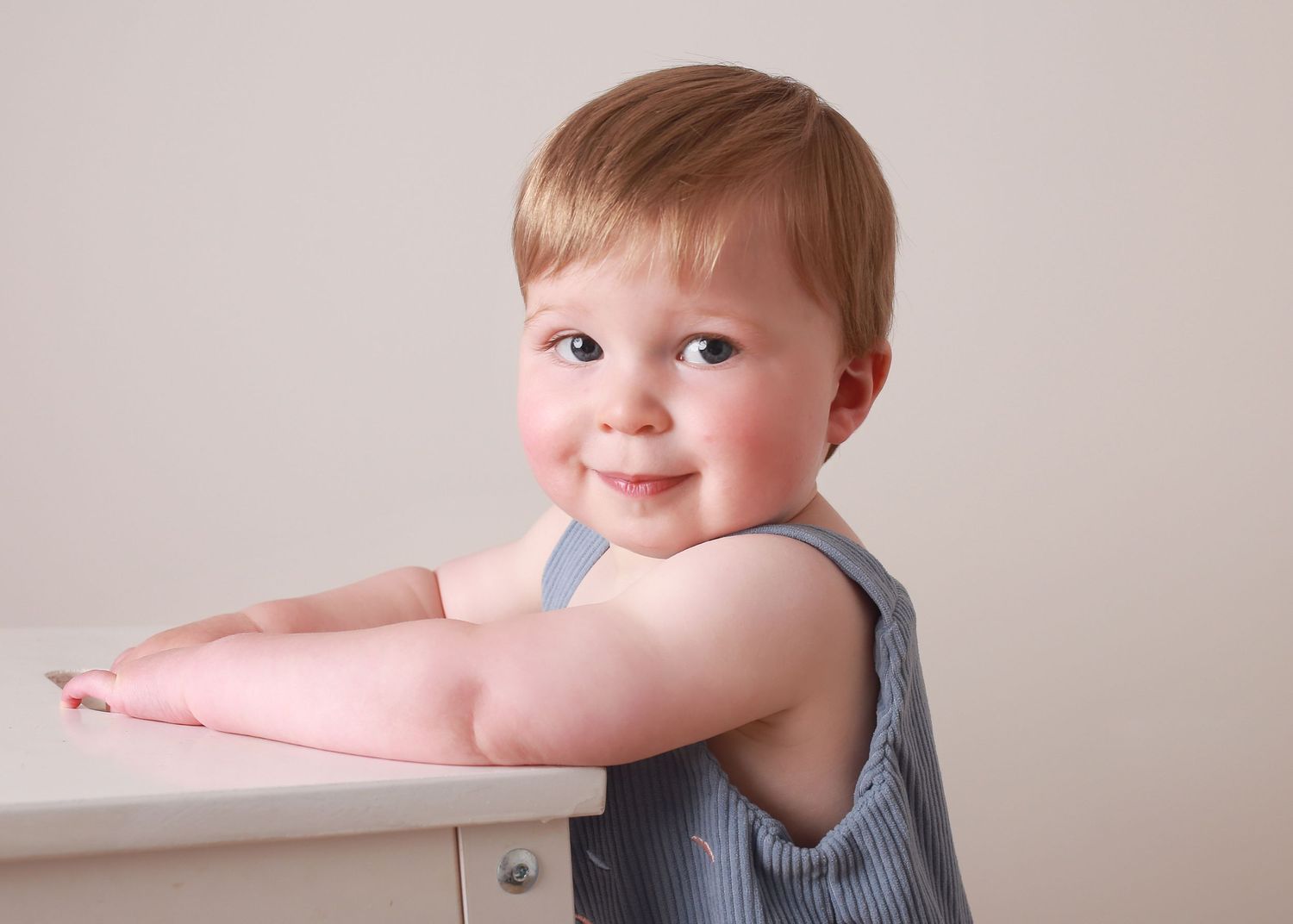 A cheeky 1-year-old flashing a playful smile, capturing their fun and mischievous personality during a joyful  photography session