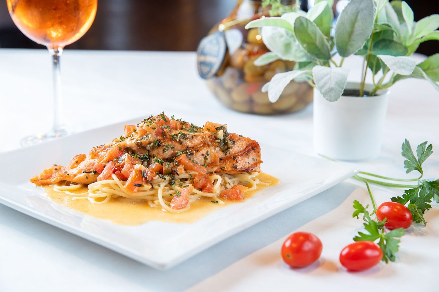 Upscale restaurant dishes with colorful garnishes and sauces plated on white dinnerware.