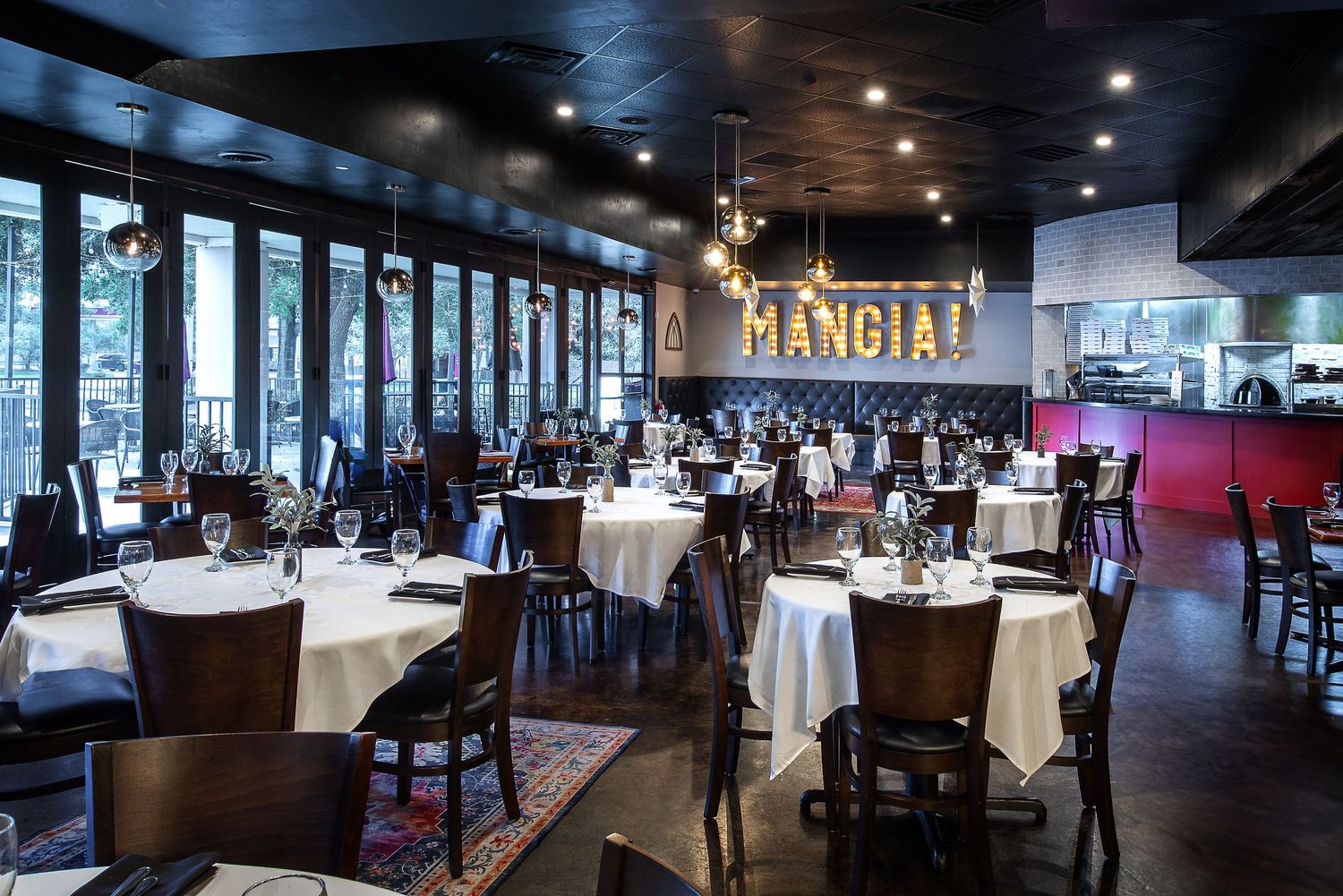 Modern restaurant interior with dark ambiance and elegant table settings.