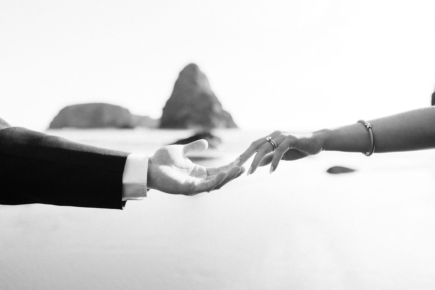 Black and white image of couple touching hands
