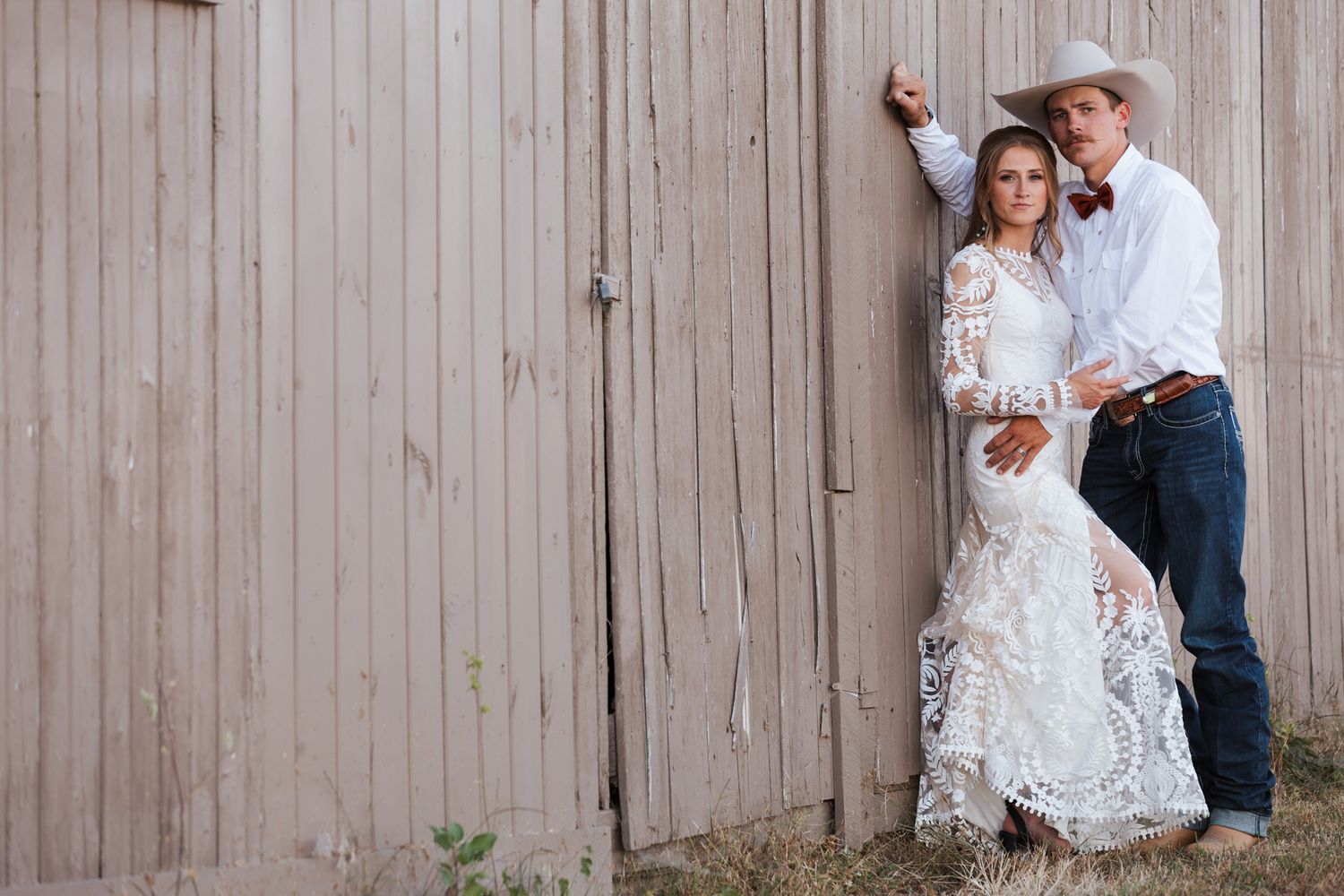 Couples in wedding attire pose playfully against rustic wooden barn siding, creating a romantic sequence of photos.