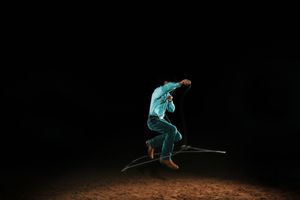 A skier performs a freestyle jump trick sequence against a dark background, showing progressive movement through the air.